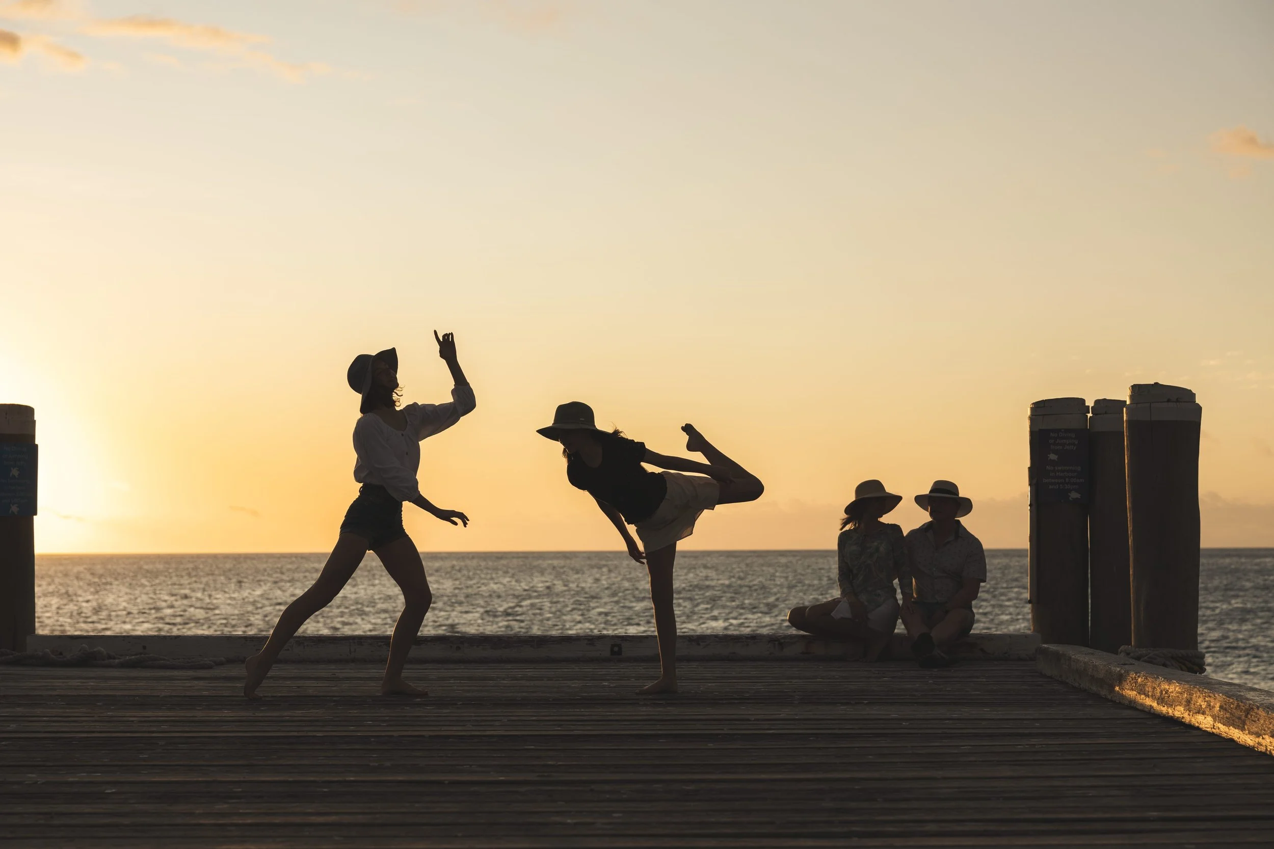 A family of four enjoying the sunset on the dock at Heron Island in the Southern Great Barrier Reef of Australia.