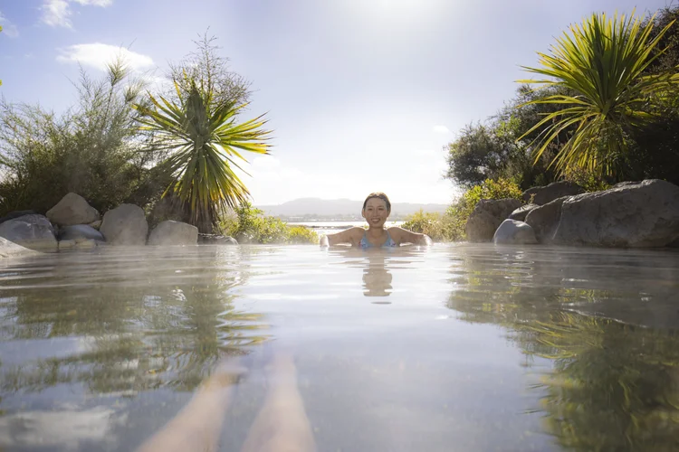 Woman sitting in the hot spring in Rotorua, New Zealand.