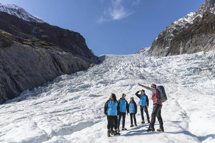 A group of people hiking a glacier in the Southern Alps during the summer with our professional guide here in New Zealand.