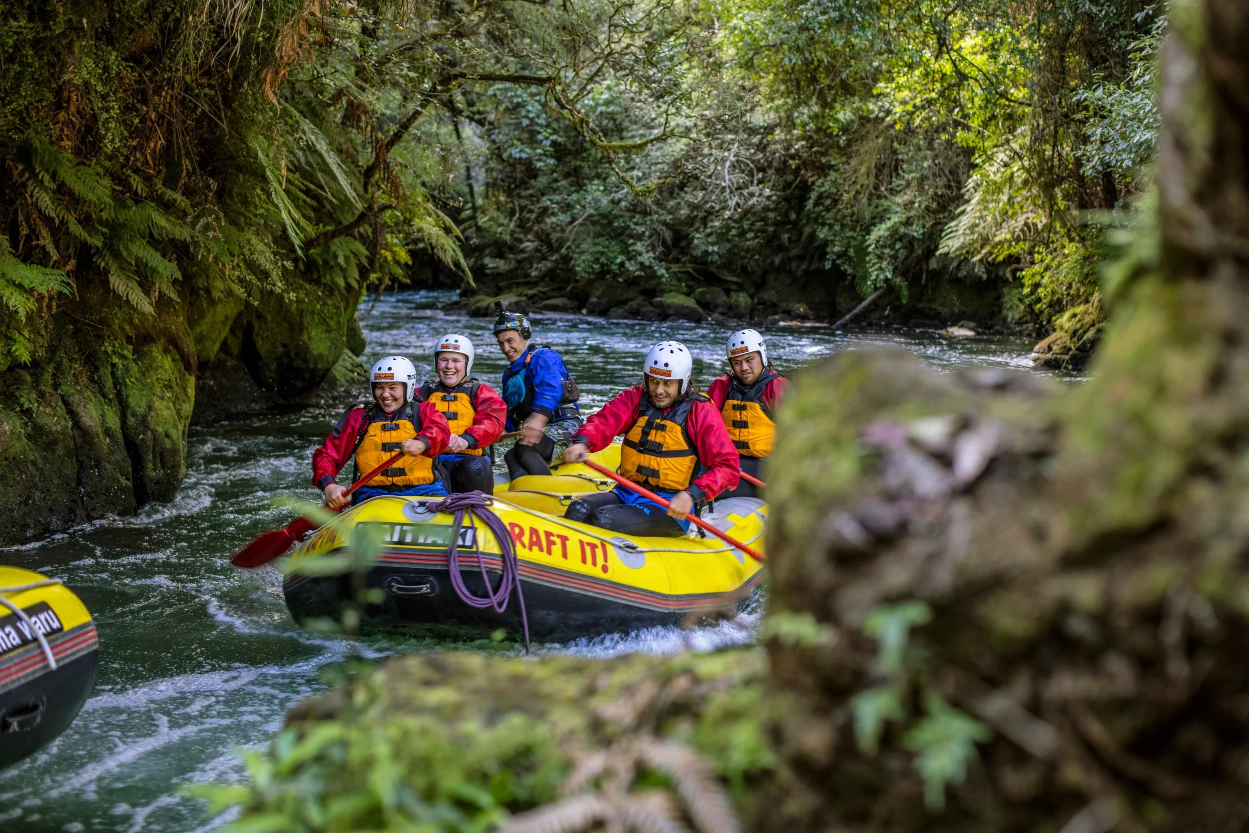 A group of rafters navigates fast-moving whitewater rapids with Kaitiaki Adventures near Queenstown, New Zealand