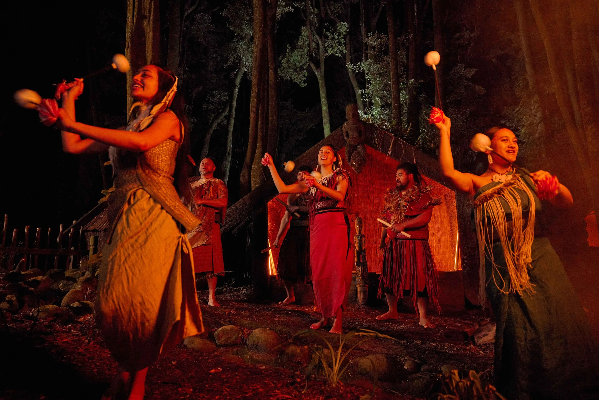 Māori performers in Rotorua, Bay of Plenty, New Zealand, showcase traditional dance with vibrant attire and cultural expression at dusk