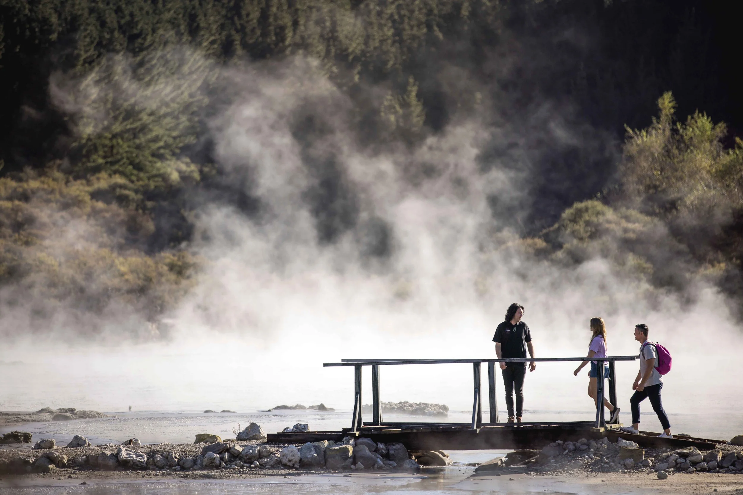 Visitors observe the steaming geothermal landscape of Rotorua, New Zealand, from a safe lookout point