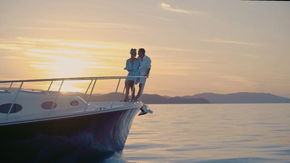 A couple on a luxury yacht cruise at sunset in the Great Barrier Reef, New Zealand.