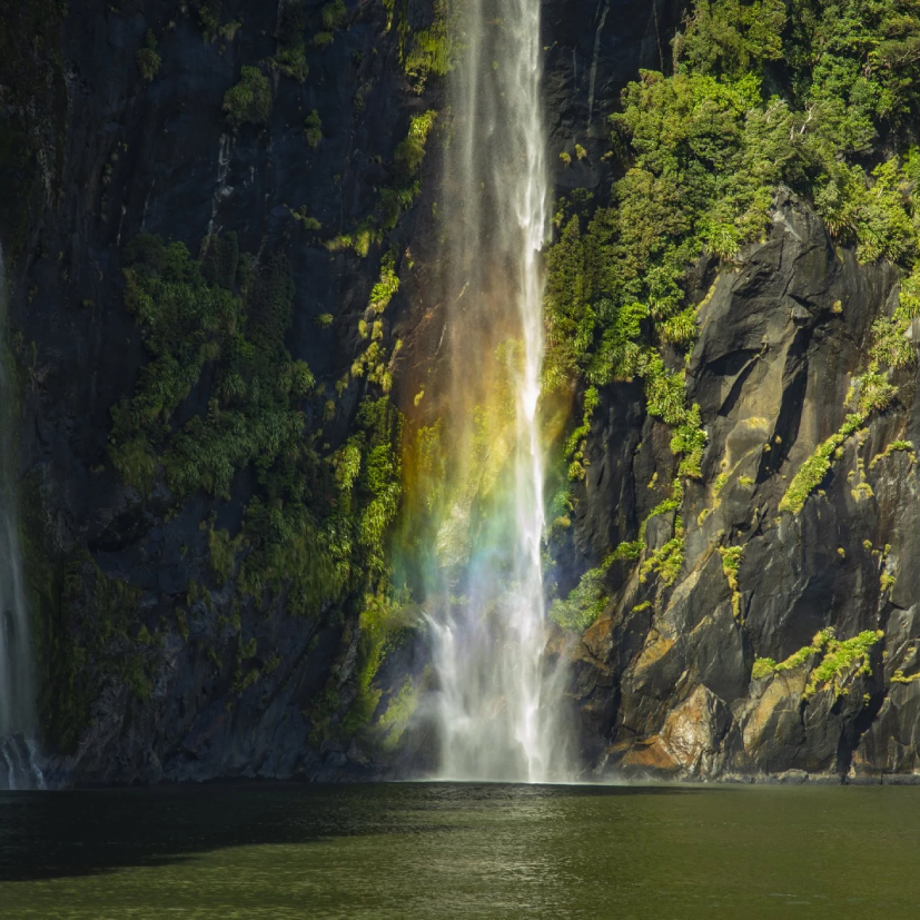 Rainbow forming on a waterfall in Marlborough Sounds on the South Island of New Zealand.