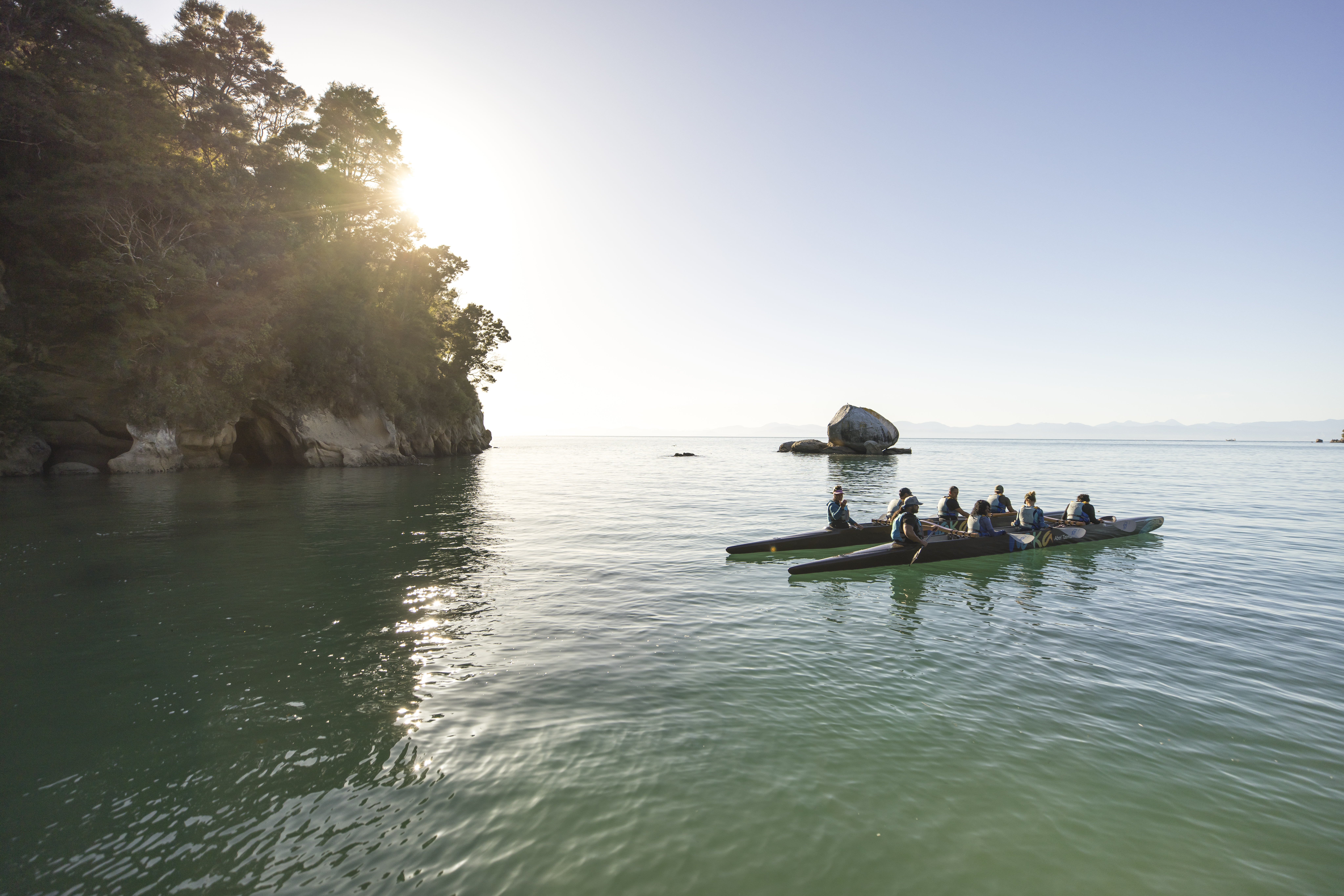 A group of travelers enjoys guided kayaking in Abel Tasman National Park, New Zealand.
