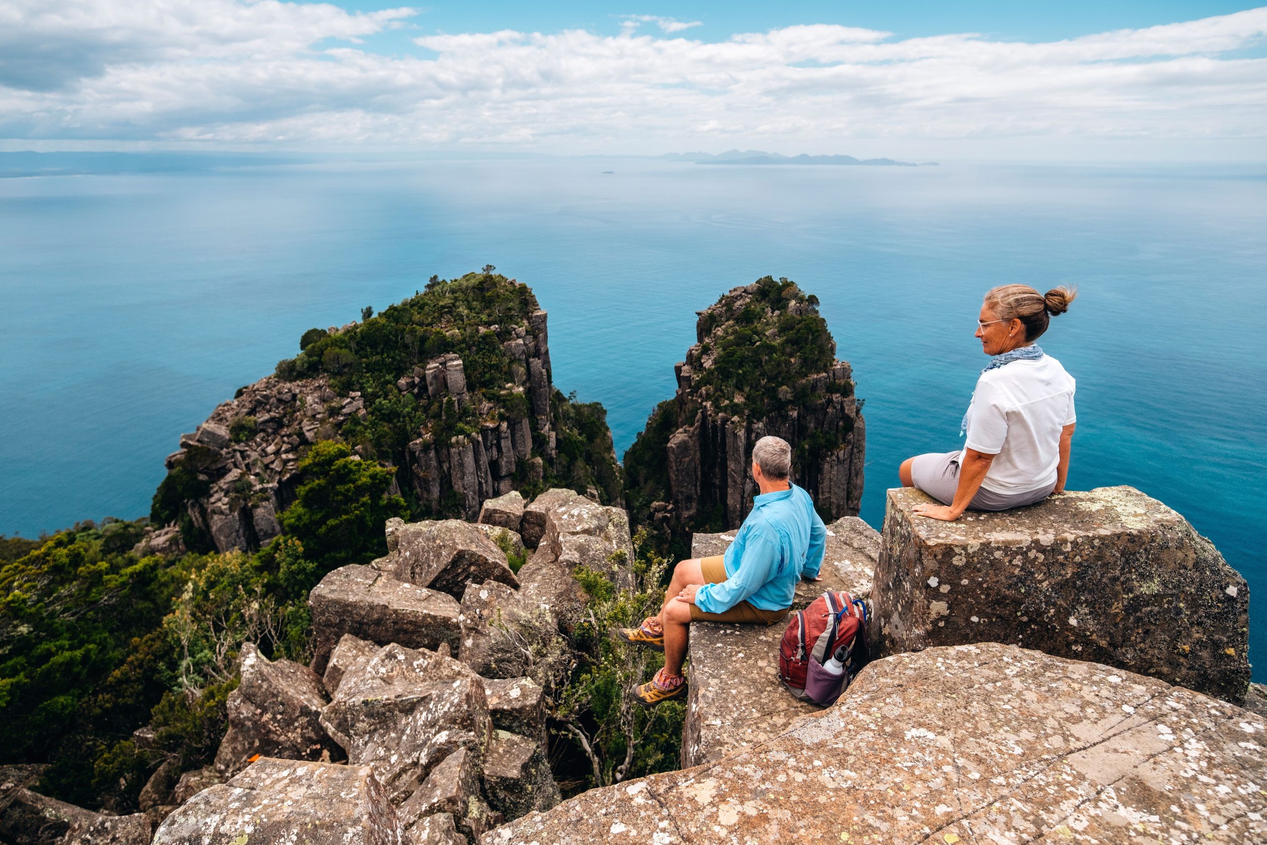 Two senior travelers enjoy a guided hike in Bishop and Clerk on Maria Island in Tasmania, Australia.