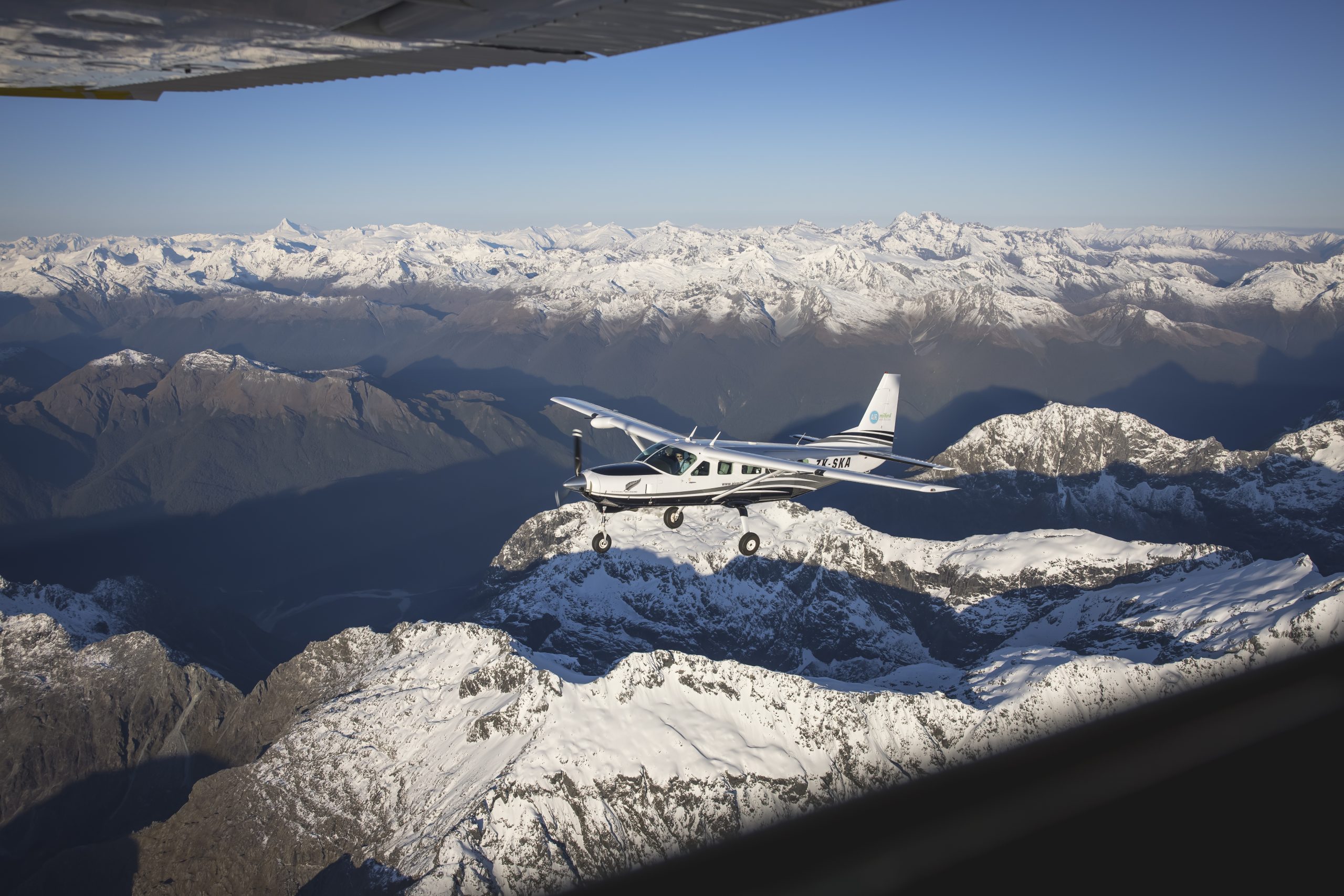 Aerial shot, a private airplane tour flies over the Southern Alps.